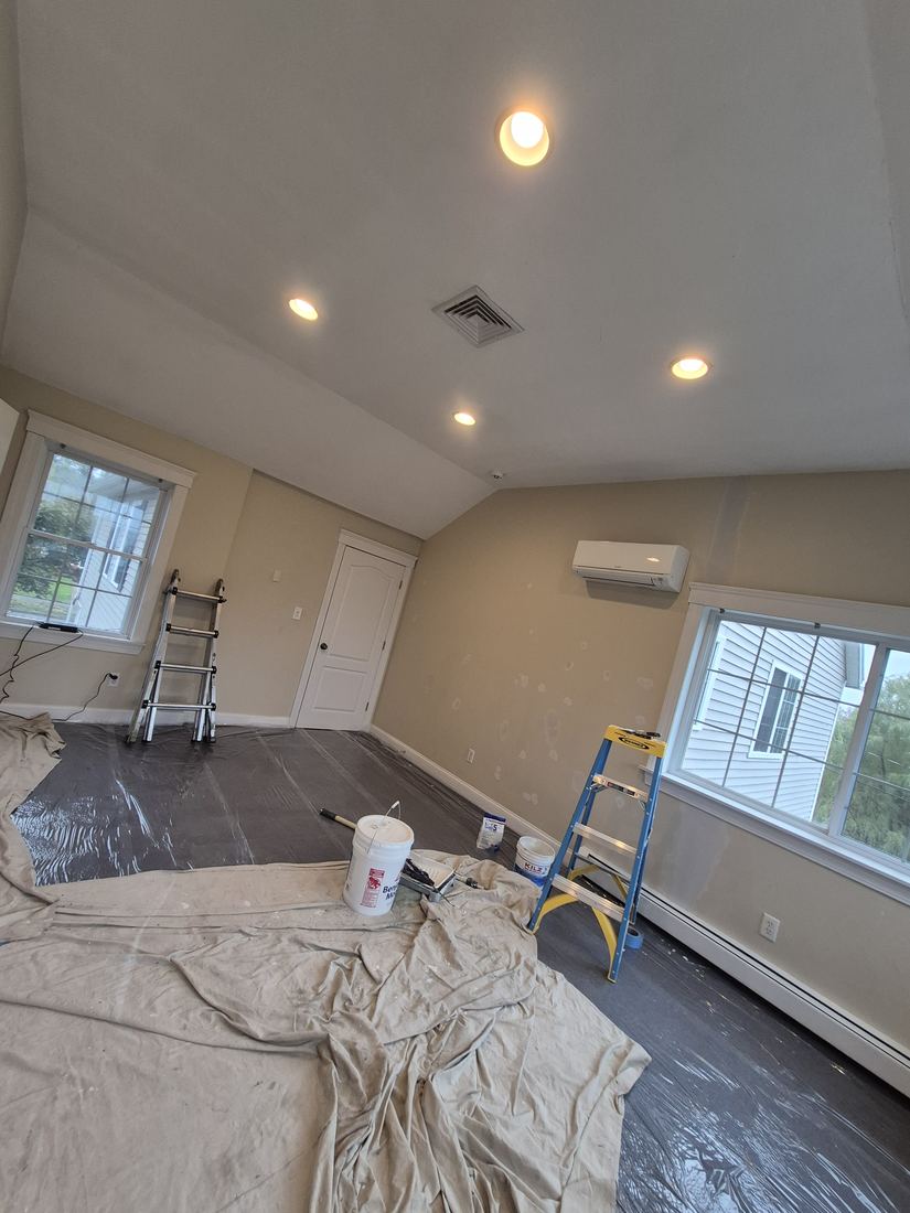 Room in Danvers, MA before painting with tan walls and drop cloths