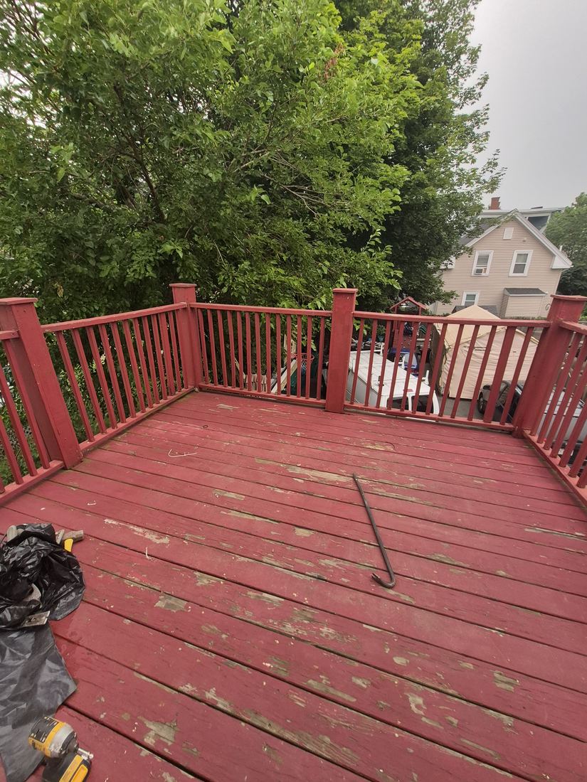 Deck in Lynn, MA before repair with peeling red paint and worn boards