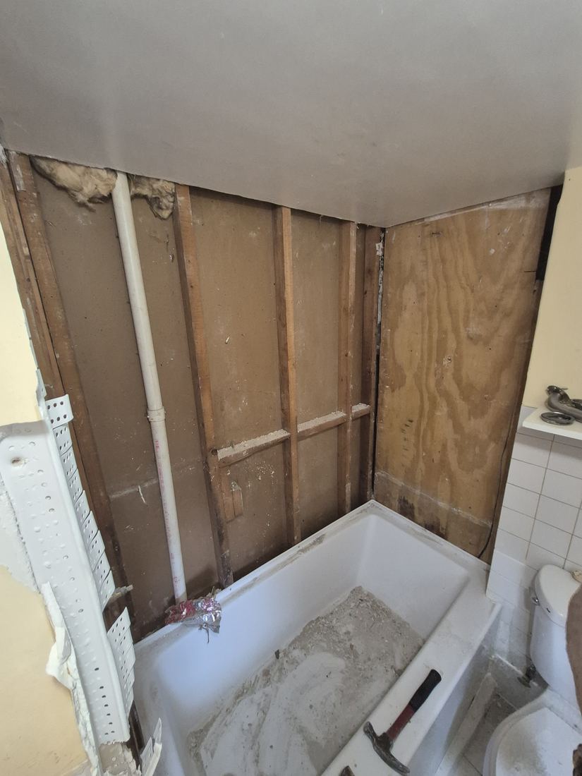 Tub in Lynn, MA with wall framing exposed before conversion to a shower
