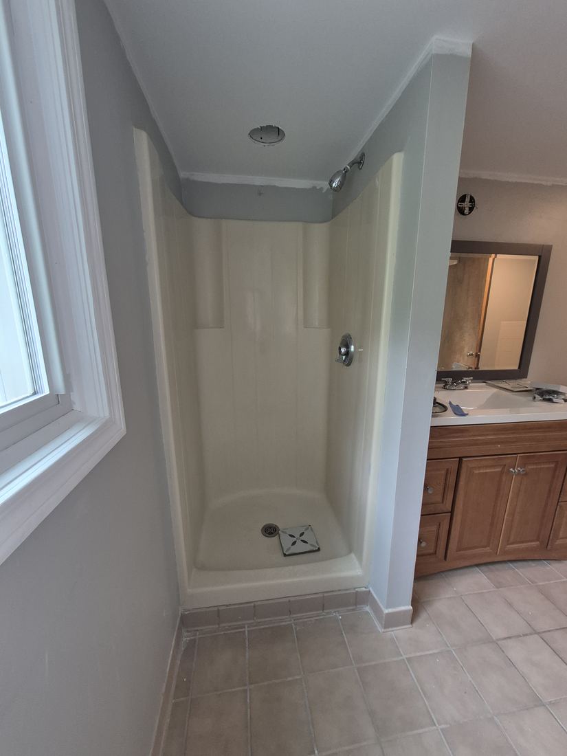 Bathroom in Salem, MA before remodel with a fiberglass shower stall