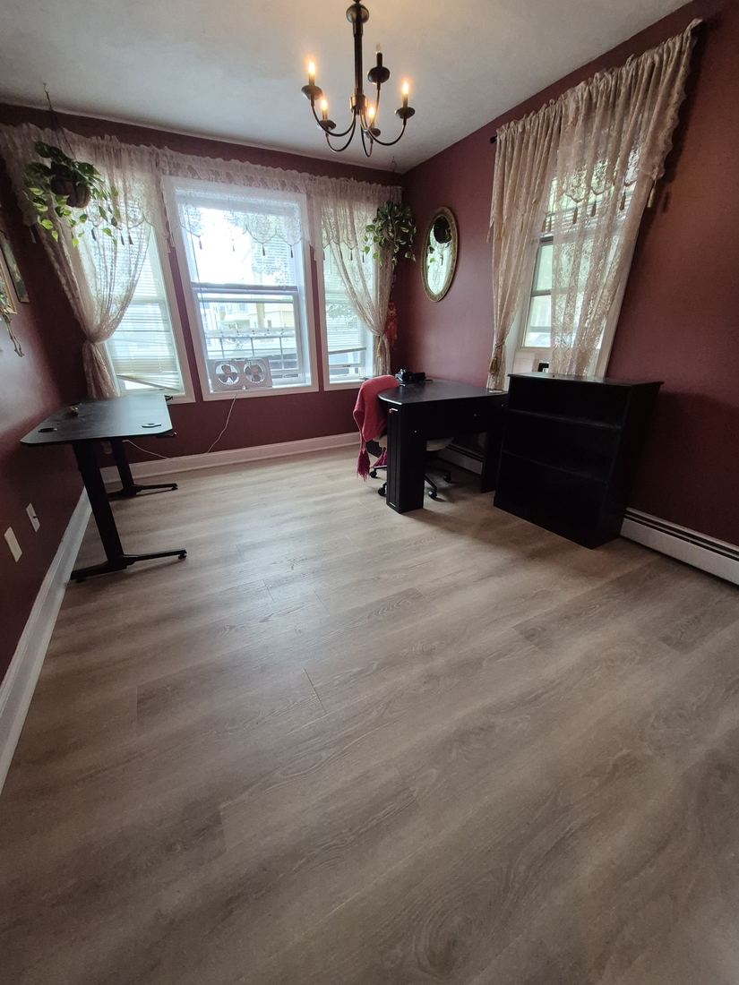 Dining room in Salem, MA after flooring installation with new light wood-look plank flooring