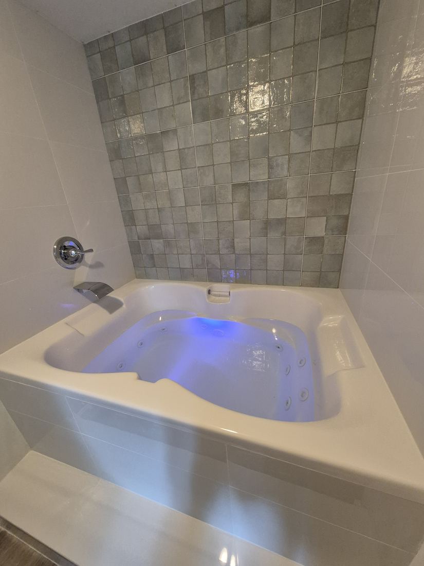Jetted tub in Salem, MA after remodel with a green tile feature wall and new tub surround
