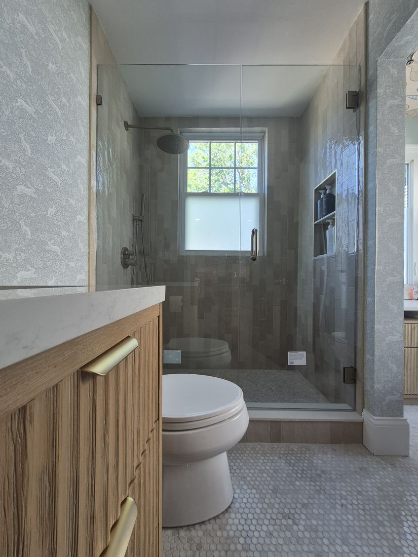 Bathroom in Salem, MA after tub-to-shower conversion with tiled glass shower and wood vanity