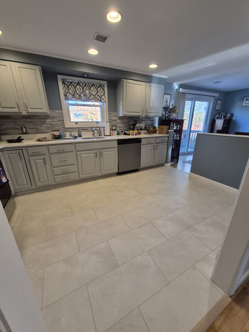 Kitchen in Woburn, MA after floor installation with large light tile-look flooring